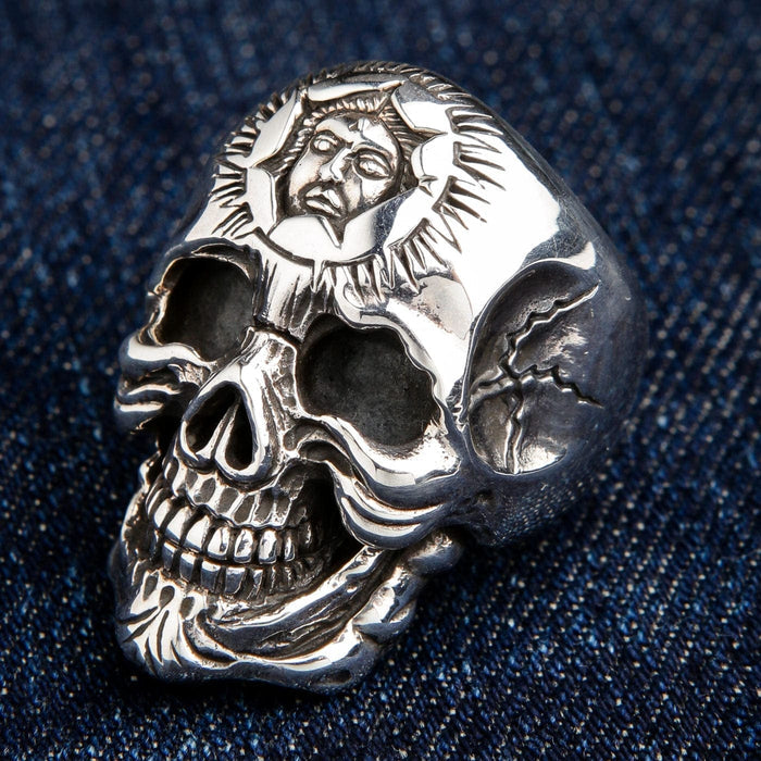 A heavy 42 gram men's sun god skull ring in solid 925 sterling silver, shown on a denim background.