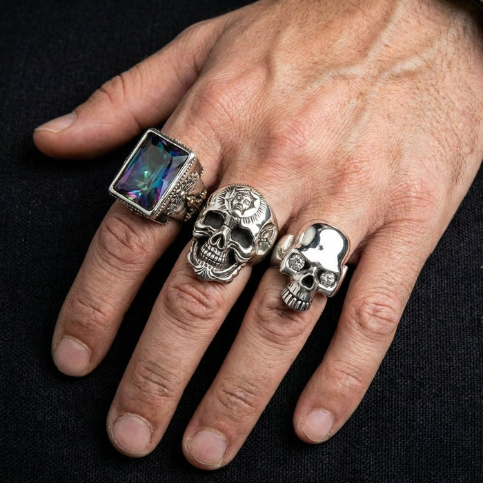 A lifestyle shot showing a man wearing the heavy biker skull ring alongside other silver rings.