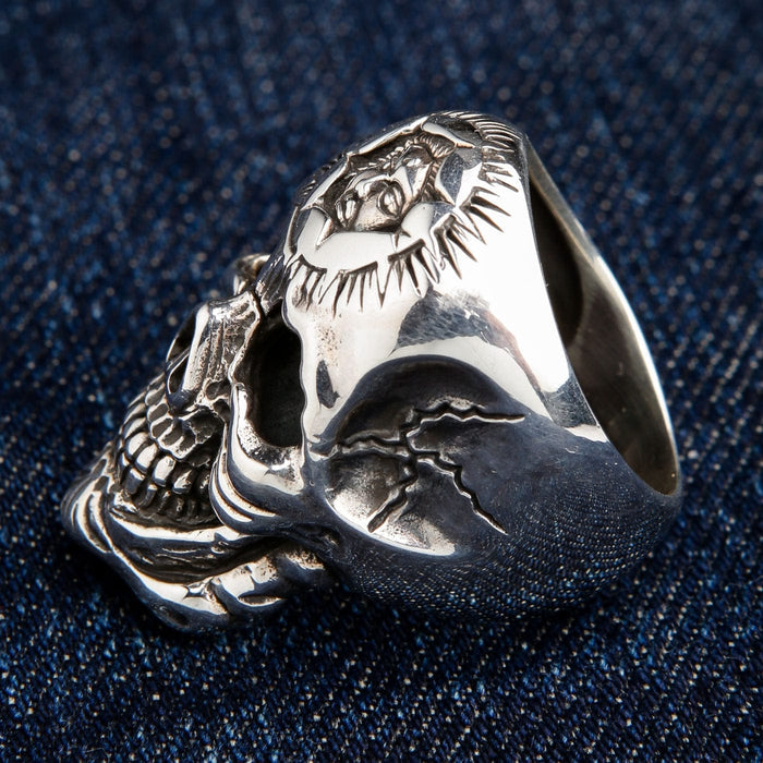 A side view of the heavy silver skull ring, showing the 42-gram bulk and the carved crack detail on the band.