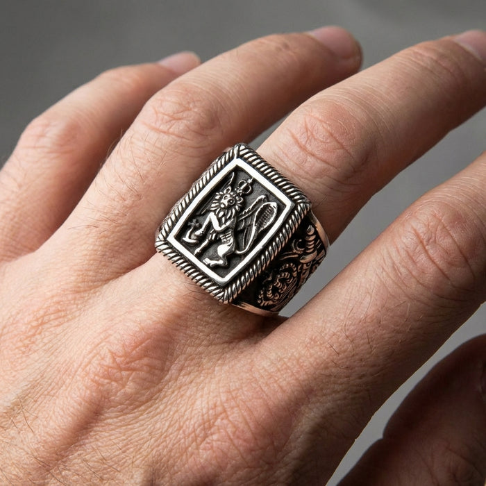 A man's hand wearing the massive and detailed sterling silver Venetian lion ring to demonstrate its impressive scale.